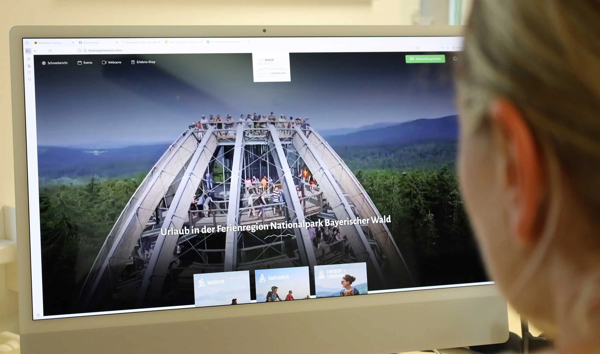 Frau plant ihren Urlaub am Laptop in einem hellen Raum
