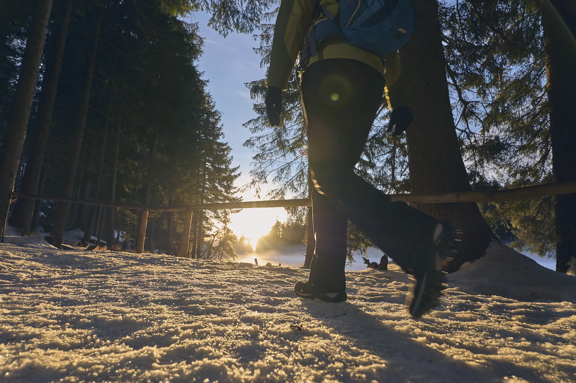 Wanderer mit Spikes an den Winterschuhen umrundet den Großen Arbersee Fußgänger geht mit Grödeln auf einem verschneiten Winterweg