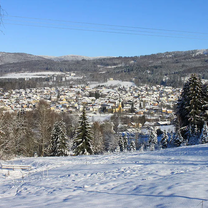 Winterlandschaft mit schneebeckter Gemeinde Frauenau Das Bild zeigt den Skilift über Frauenau