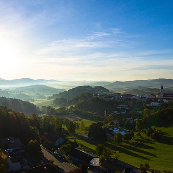 Harmonische Naturaufnahme des Markt Schönberg mit klarer Luft und strahlendem Himmel Ein weites Panorama rund um Schönberg, das in der diesigen Morgenbeleuchtung erstrahlt mit blauem Himmel.