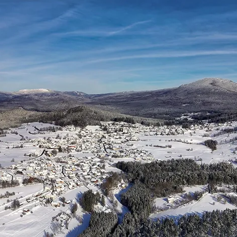 Panoramablick auf Lindberg mit verschneiten Bergen im Hintergrund Die winterliche Szenerie zeigt die Ferienregion und den Ort Lindberg