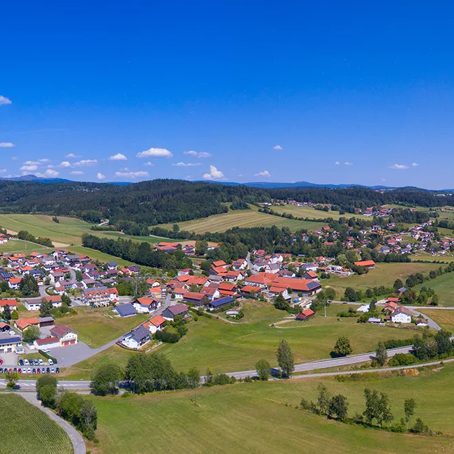 Panoramablick auf Eppenschlag mit den sanften Hügeln des Mittelgebirges unter kräftig blauem Himmel Eine weite Landschaft eröffnet sich rund um Eppenschlag, einem kleinen Dorf unter strahlend blauem Himmel, der die Idylle unterstreicht.