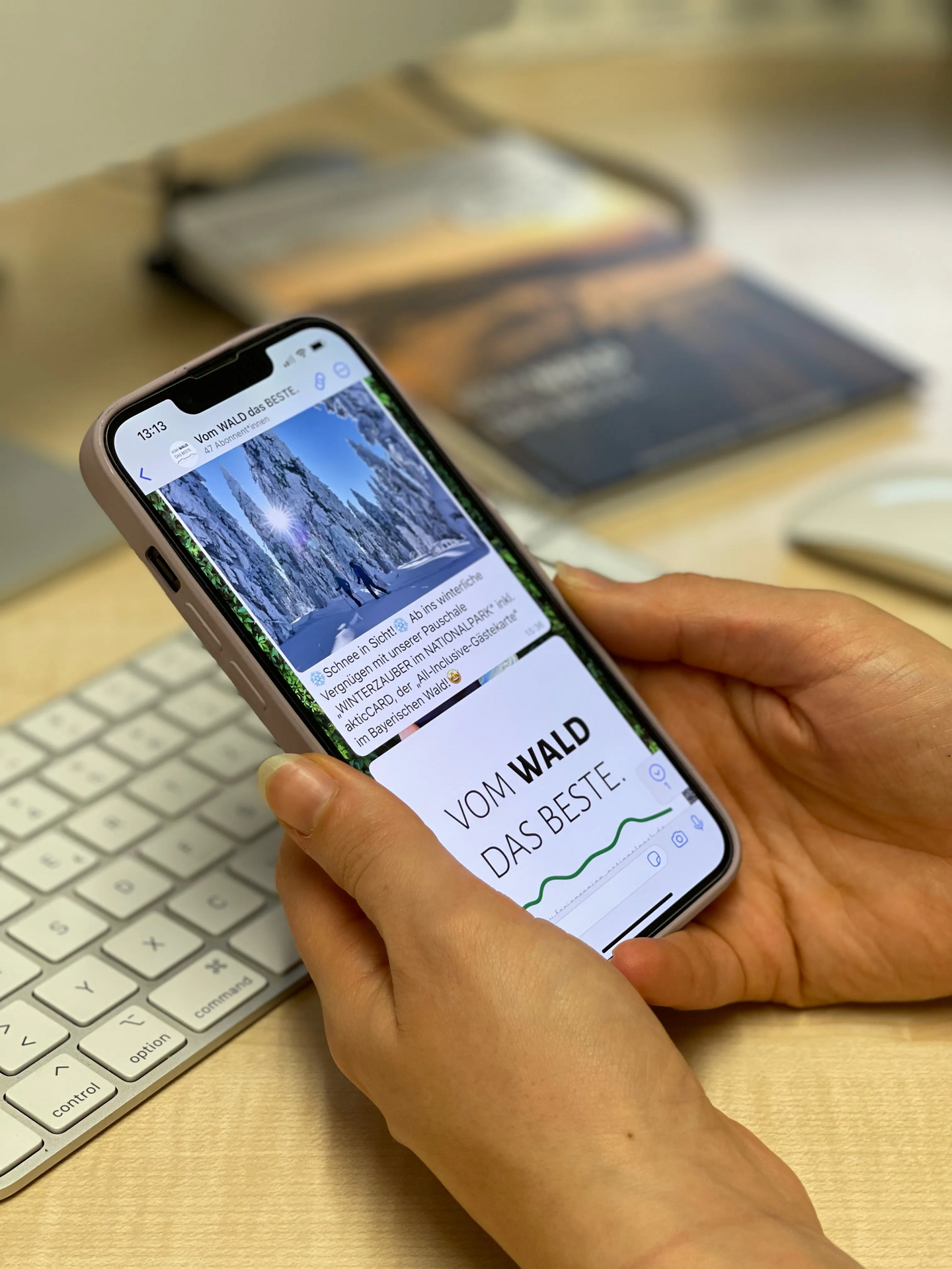 Smartphone zeigt beeindruckende Winteransicht und Informationen WhatsApp Kanal der Ferienregion