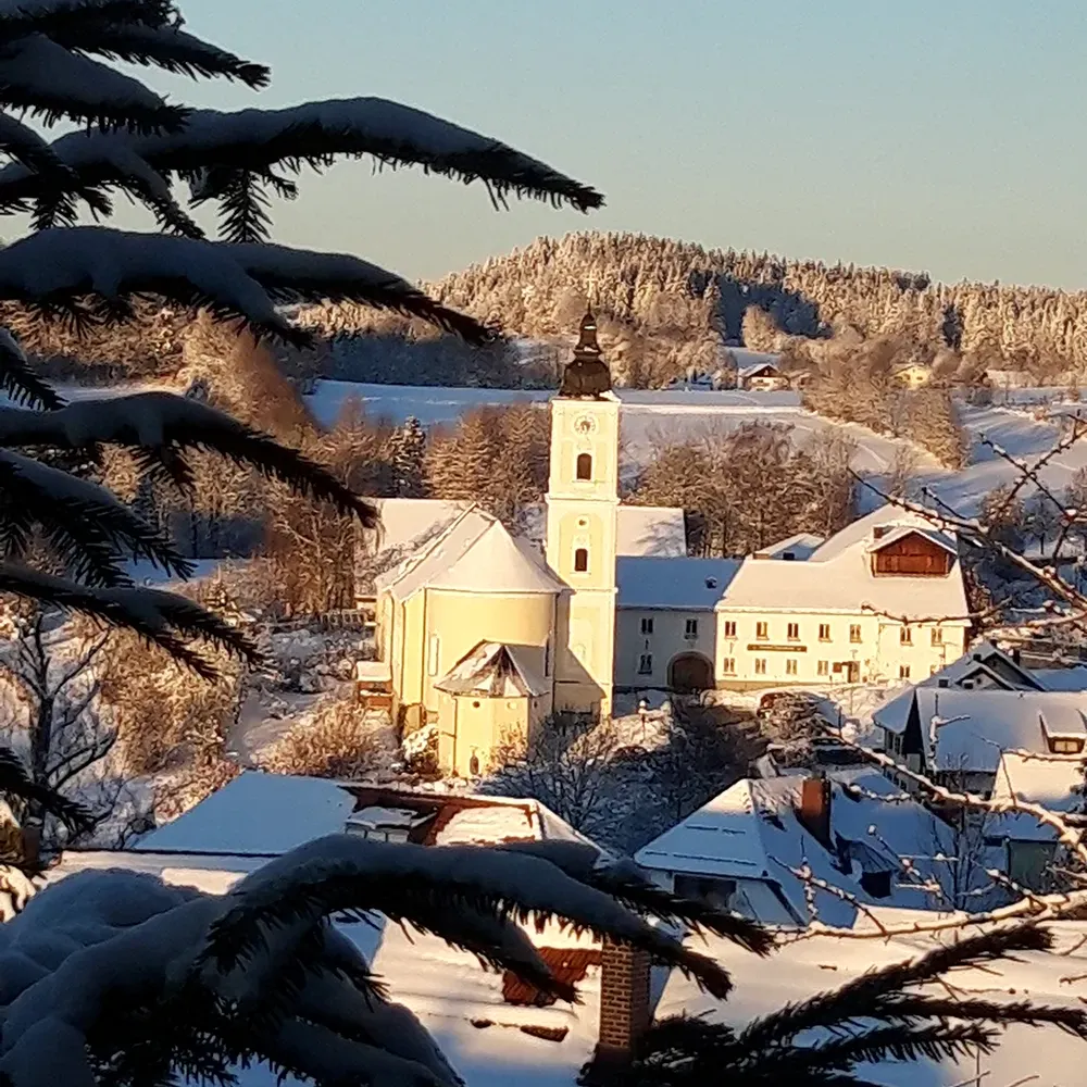 Frostige Morgenatmosphäre rund um die im Winterkleid liegende Klosterkirche St. Oswald